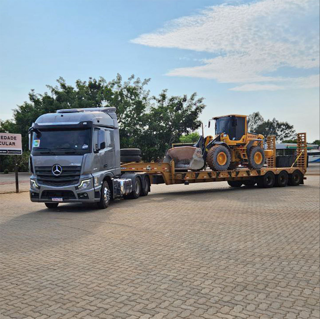 Carreta e prancha 02 eixos fazendo transporte de uma retroescavadeira